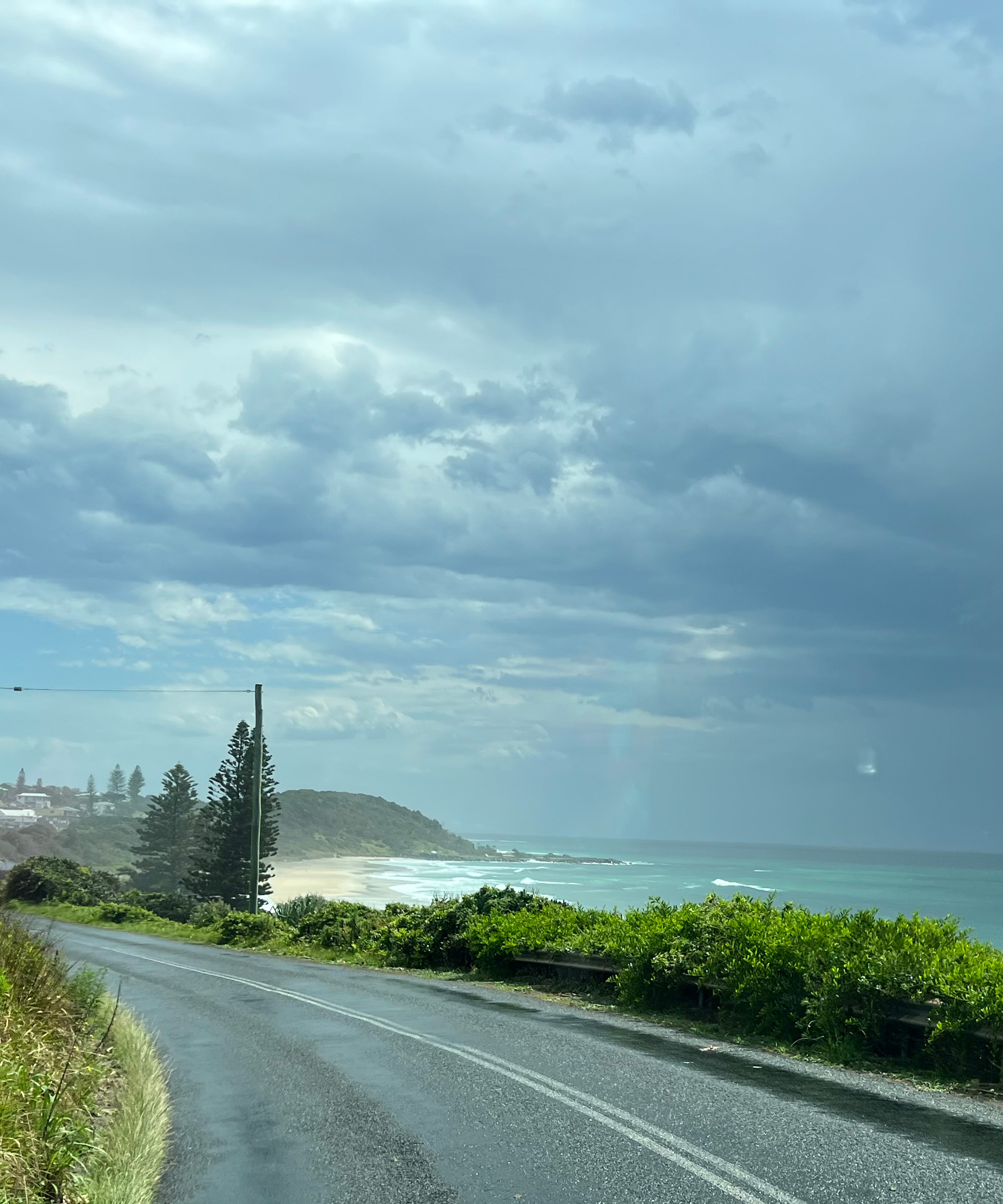 Coastal road with ocean and beach in the foreground.
